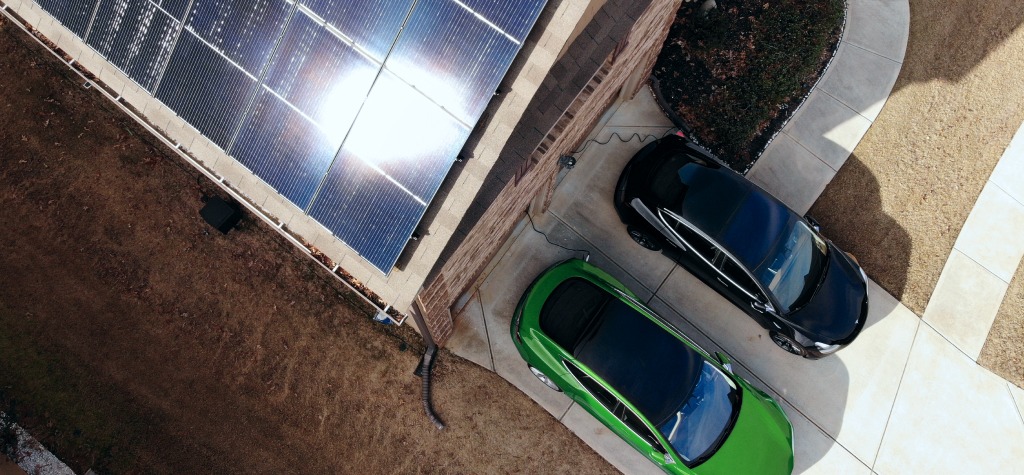 E-Autos stehen vor einem Haus mit Solar zum Überschussladen mit einer Wallbox