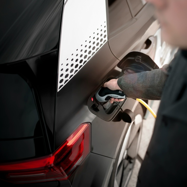 man charging his car at an EV charging station