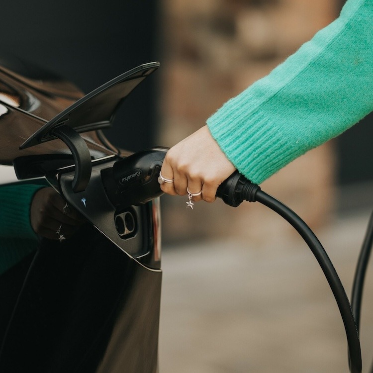 Woman charging Tesla using tethered Zappi EV charger